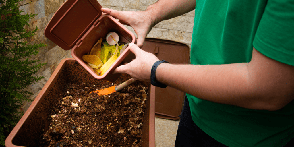 Homme qui vide son compost chez lui