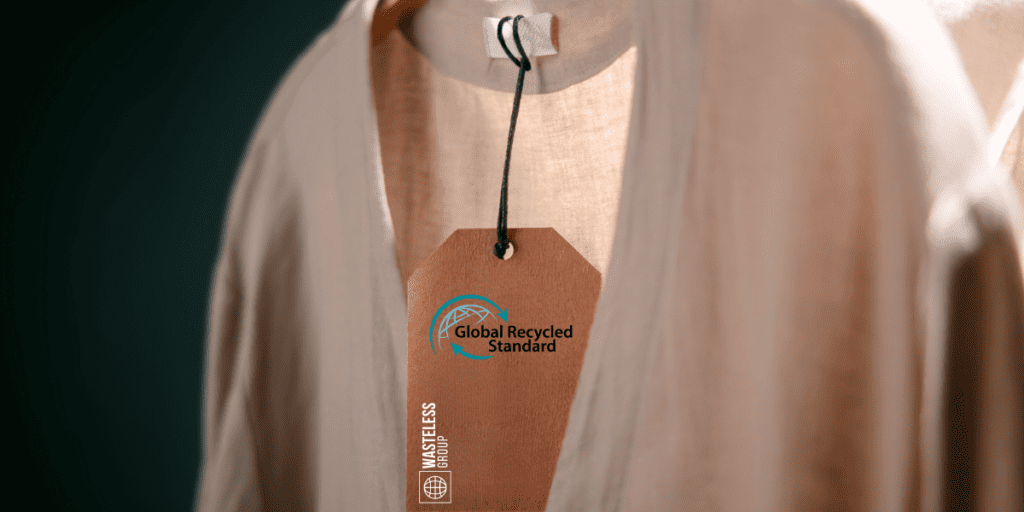 T-shirt beige pendu sur un cintre avec une étiquette portant le label GRS