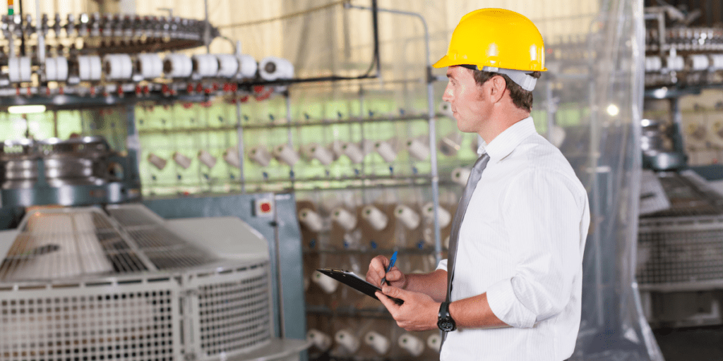 Homme avec casque et tablette contrôlant une machine textile