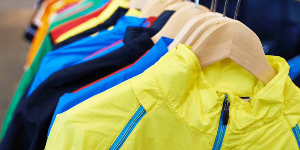Plusieurs vêtements de sport colorés accrochés sur une penderie