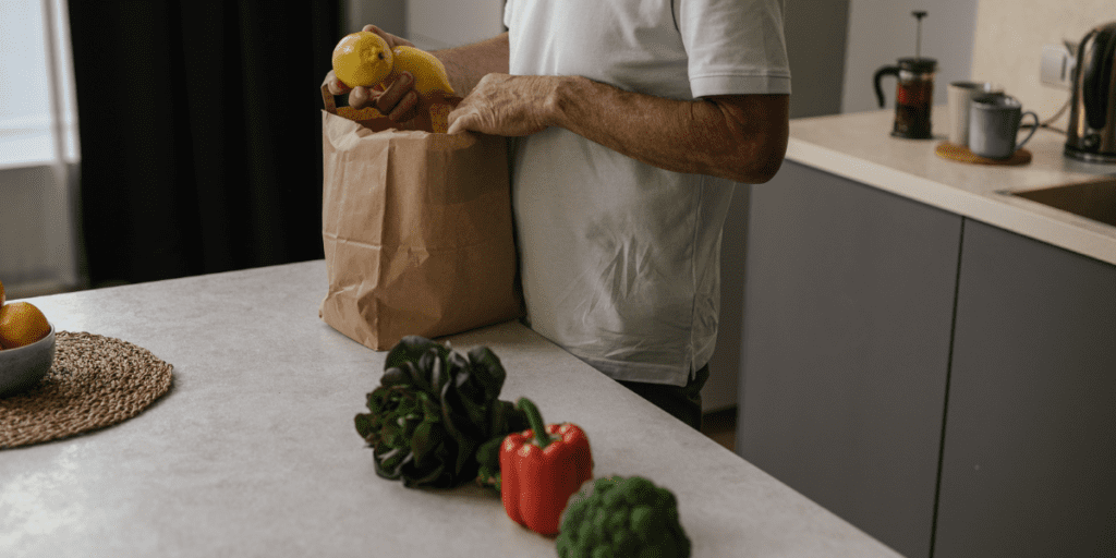 Personne qui vide des légumes d'un sac en papier Kraft