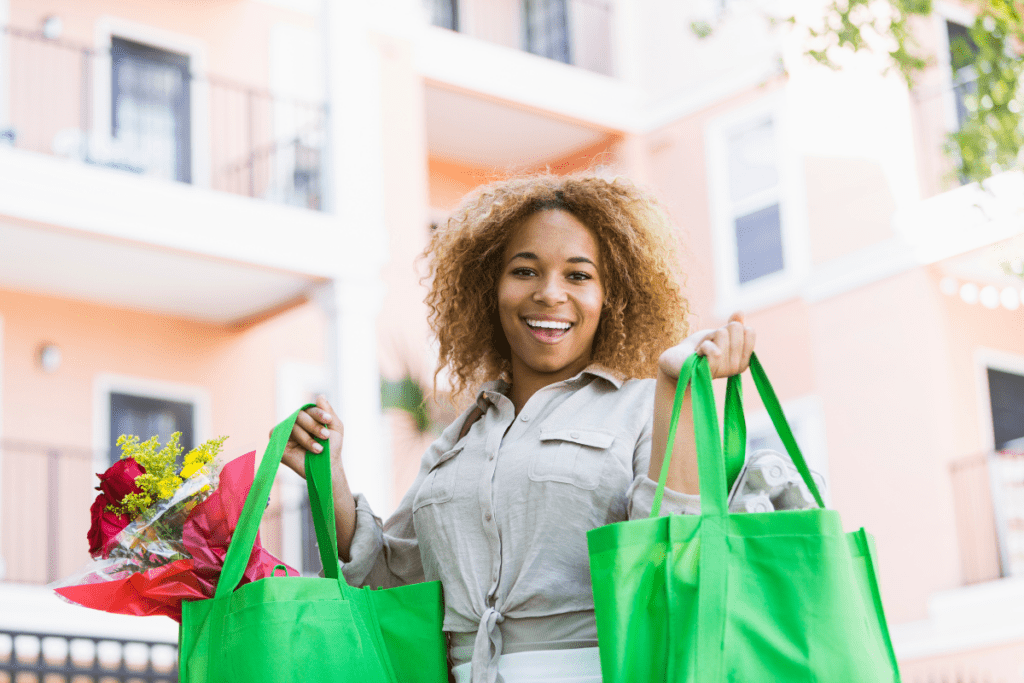 Consommateur éco-responsable utilisant un sac cabas réutilisable à la sortie de ses courses en supermarché.